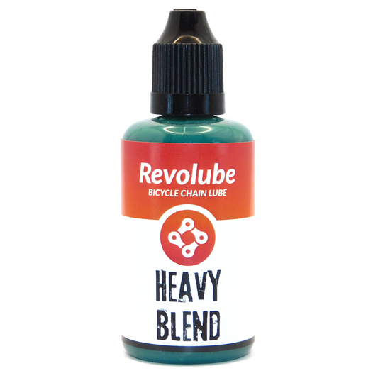 A 50ml plastic bottle of Revolubes Bicycle Chain Lube in Heavy Blend variant, designed for maximum drivetrain protection in extreme conditions, displayed against a white background.